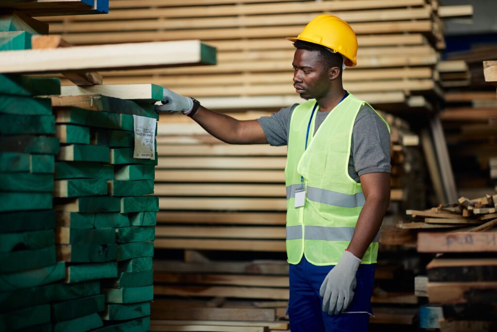 Young black man working at lumber distribution warehouse.